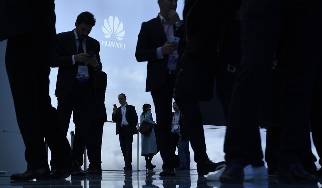Visitors use their mobile phone at a Huawei stand. Photo: AFP