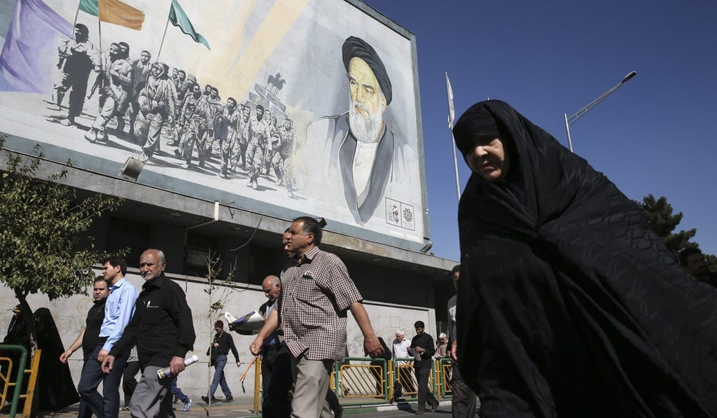 Iranian worshippers walk past a painting of the late revolutionary founder Ayatollah Khomeini at the conclusion of a prayer ceremony in Tehran. Photo: AFP