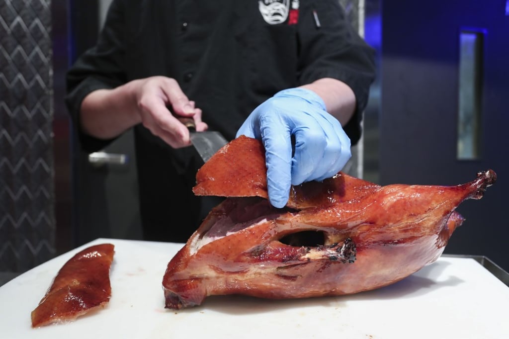 Carving the slow-roasted whole duck. Photo: Jonathan Wong