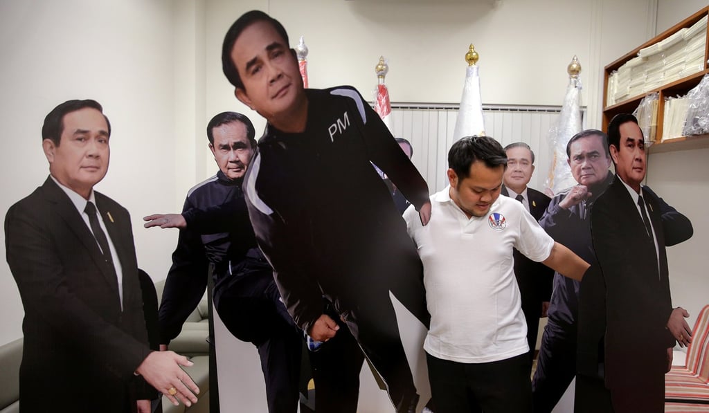 A government official arranges cardboard cut-outs of Thailand's Prime Minister Prayuth Chan-ocha at Government House in Bangkok. Photo: Reuters