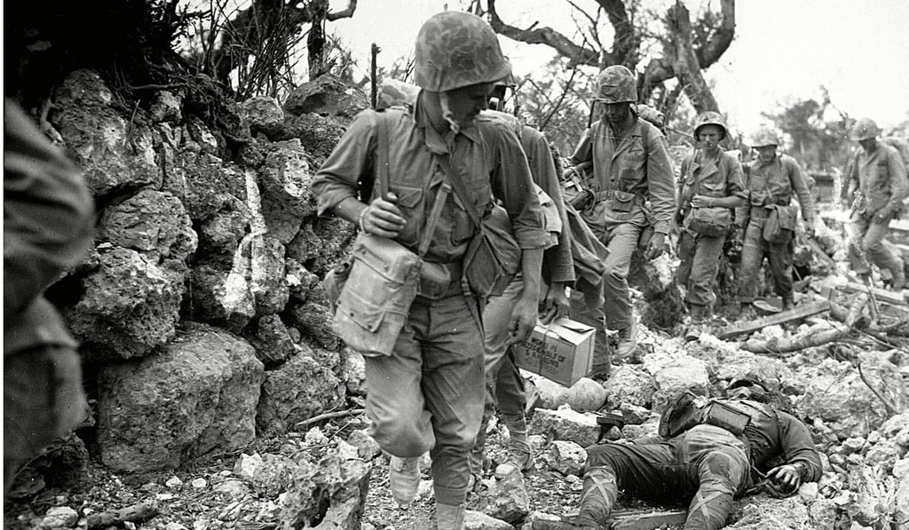 US Marines pass through a small village in Okinawa, where Japanese soldiers lay dead, during the second world war. Many ‘Yosegaki Hinomaru’ flags were taken as war souvenirs by Allied soldiers. Photo: AFP