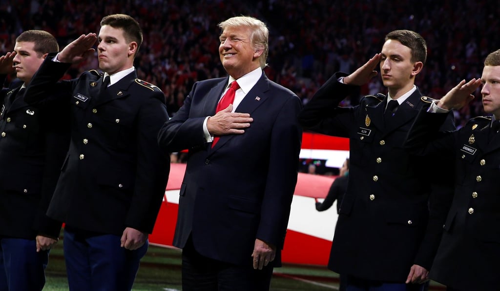 US President Donald Trump stands with ROTC students to participate in the national anthem before the NCAA College Football Championship game between Alabama and Georgia in Atlanta. Photo: Reuters