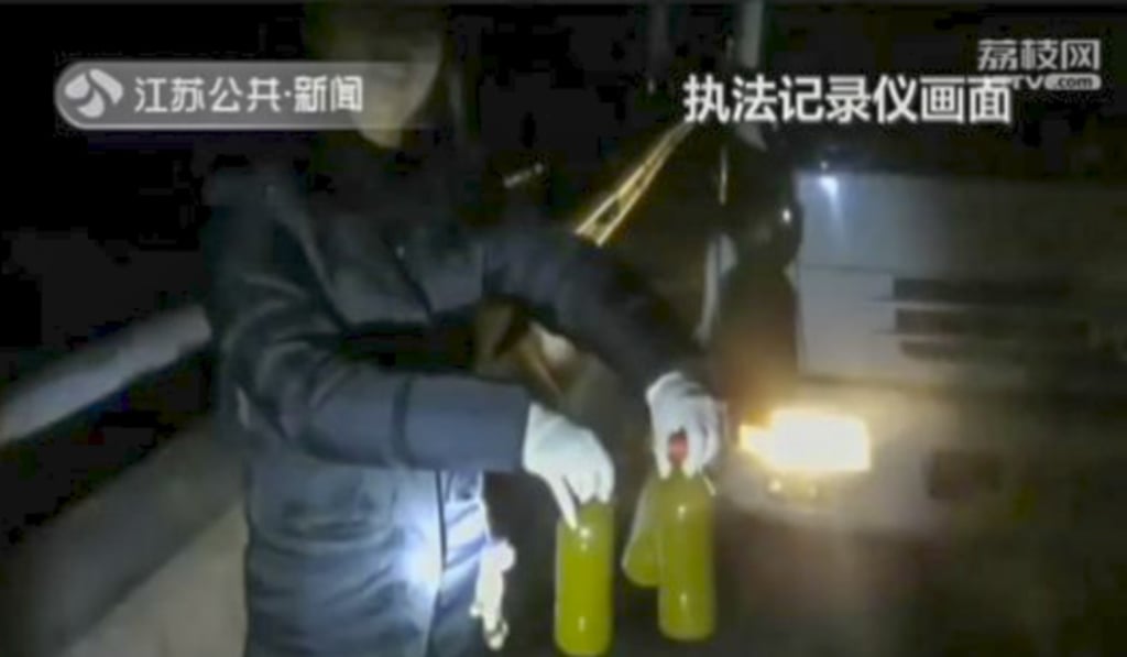 An official showing the bright yellow liquid the tanker was spraying on to the streets. Photo: People.com.cn