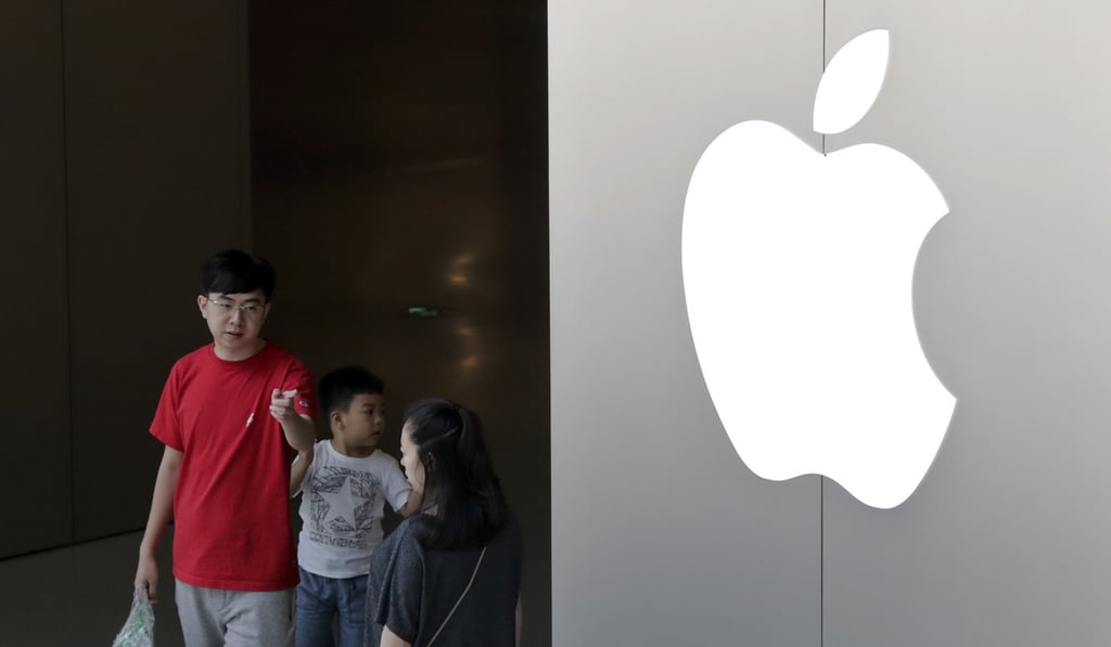 A Chinese family walks out of an Apple store in Beijing. Apple sells more than 200 million iPhones a year these days, up from 40 million in its 2010 financial year. Photo: AP