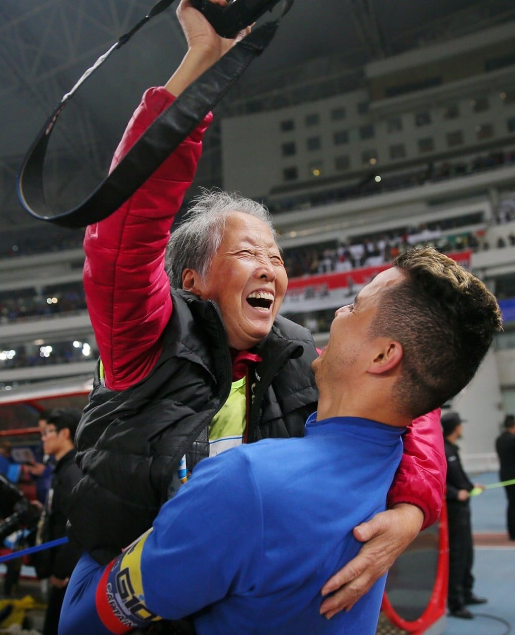 Shanghai Shenhua's Giovanni Moreno (right) lifts up photographer Hong Nanli after a Chinese FA football match between Shanghai Shenhua and SIPG in Shanghai. Photo: Agence France-Presse