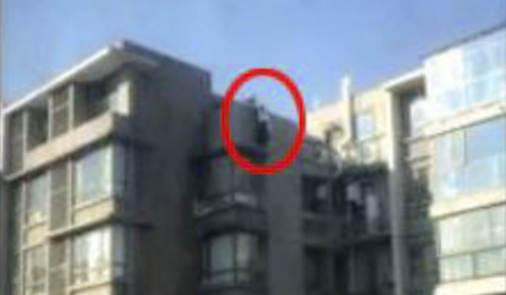 The woman pictured last week standing on a ledge before the policeman came to her aid. Photo: News.sina.com.cn