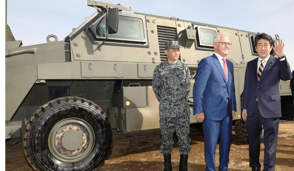 Japanese Prime Minister Shinzo Abe and his Australian counterpart Malcolm Turnbull in front of an armoured personnel vehicle. Photo: Kyodo Japanese Prime Minister Shinzo Abe and his Australian counterpart Malcolm Turnbull in front of an armoured personnel vehicle. Photo: Kyodo