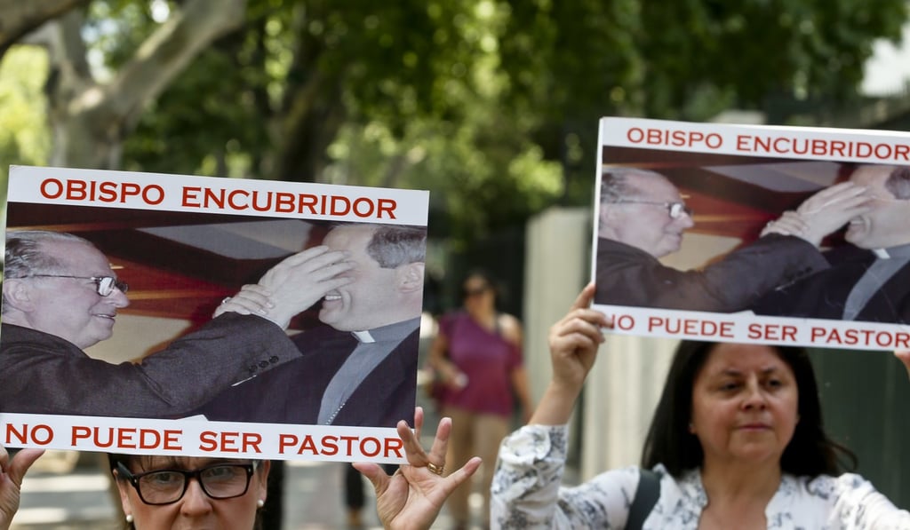 Members of the movement Laicos de Osorno hold up images showing the Reverend Fernando Karadima, and his protégé Juan Barros, bishop of Osorno, with a message that reads in Spanish: “A bishop who covers up cannot be a priest,” during a demonstration in front of the Apostolic Nunciature, in Santiago, Chile, on January 12, 2018. Photo: AP Members of the movement Laicos de Osorno hold up images showing the Reverend Fernando Karadima, and his protégé Juan Barros, bishop of Osorno, with a message that reads in Spanish: “A bishop who covers up cannot be a priest,” during a demonstration in front of the Apostolic Nunciature, in Santiago, Chile, on January 12, 2018. Photo: AP