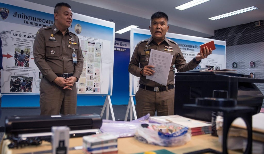 Suttipong Vongpint holds a fake Singaporean passport during a press conference in Bangkok. Photo: AFP Suttipong Vongpint holds a fake Singaporean passport during a press conference in Bangkok. Photo: AFP