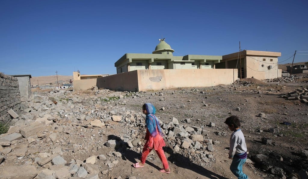 Iraqi children from the Shabak community walk past their house, which was destroyed by Islamic State militants, in the village of Baz Gerkan east of Mosul on January 10, 2018. Shabaks, who number around 60,000 in Iraq, were targeted by Islamic State, and many fled their homes during the three years of jihadist occupation. Photo: AFP