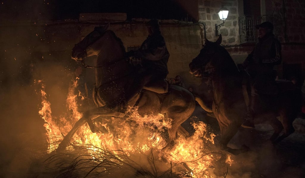 Horsemen jump over a bonfire the opening of the Luminarias festival. Photo: AP Horsemen jump over a bonfire the opening of the Luminarias festival. Photo: AP