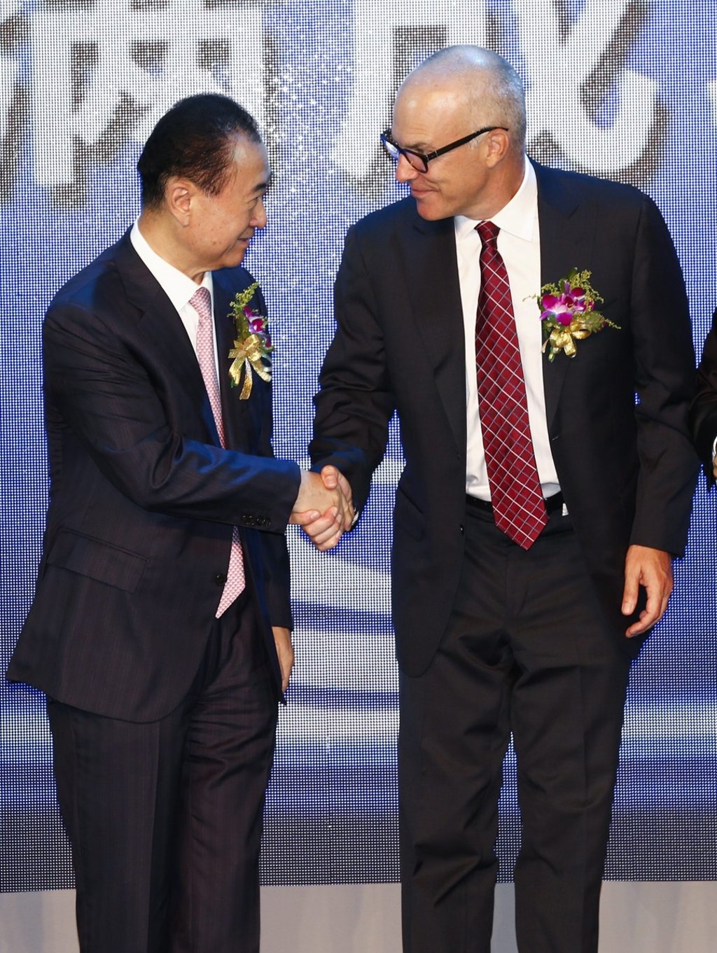 Wang Jianlin (L), founder of Dalian Wanda Group, and World Triathlon Corp’s chief executive Andrew Messick (R) during a signing ceremony at a hotel in Beijing on 27 August 2015. Wanda bought WTC for US$650 million plus debt. The WTC, under Providence Equity Partners, licenses the Ironman brand. Photo: EPA