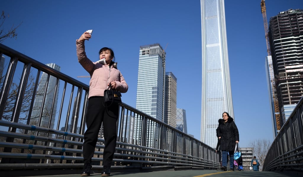 A woman takes a photo on an overpass in the central business district in Beijing on January 19. Driving the crackdown on local data inflation is Beijing’s desire to have more accurate figures to shape economic policy decision-making. Photo: AFP A woman takes a photo on an overpass in the central business district in Beijing on January 19. Driving the crackdown on local data inflation is Beijing’s desire to have more accurate figures to shape economic policy decision-making. Photo: AFP