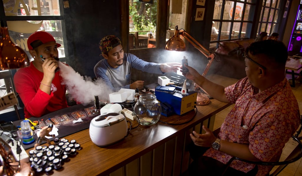 E-cigarette cafe employees and customers vape together in Jakarta. Photo: AFP
