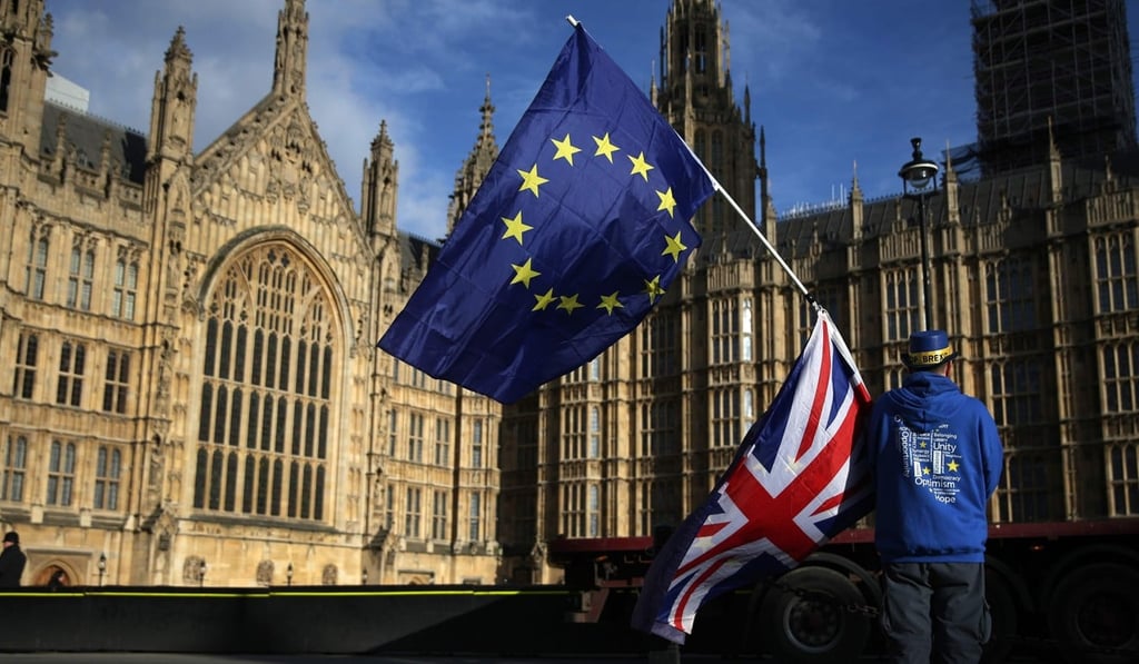 A pro-European Union,(EU), anti-Brexit demonstrator holds the EU and UK flags outside the Houses of Parliament, in central London on January 22, 2018. Photo: AFP