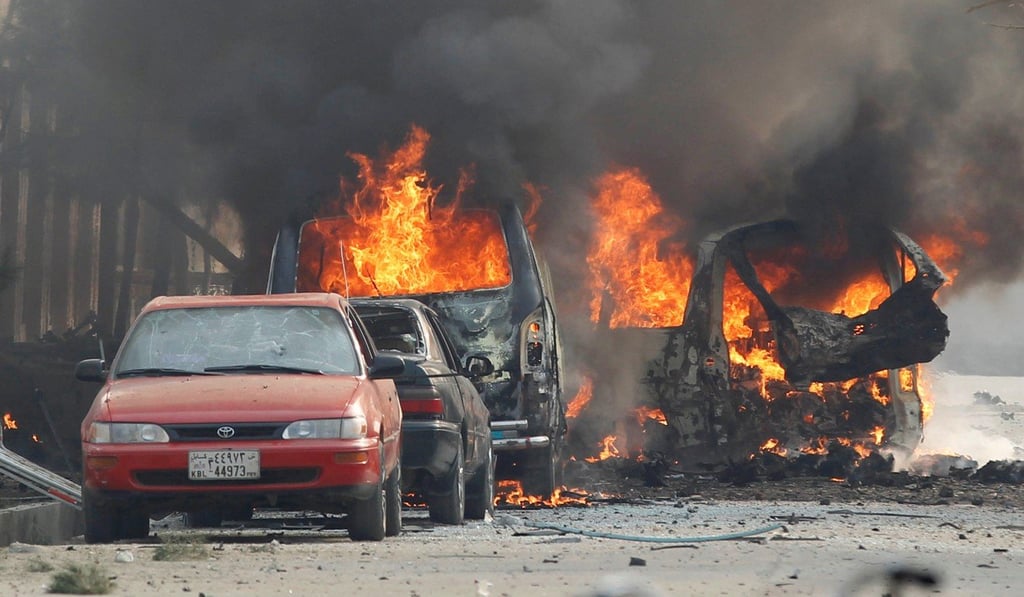 Vehicles are seen on fire outside the Save The Children compound in Jalalabad on Wednesday. Photo: Reuters