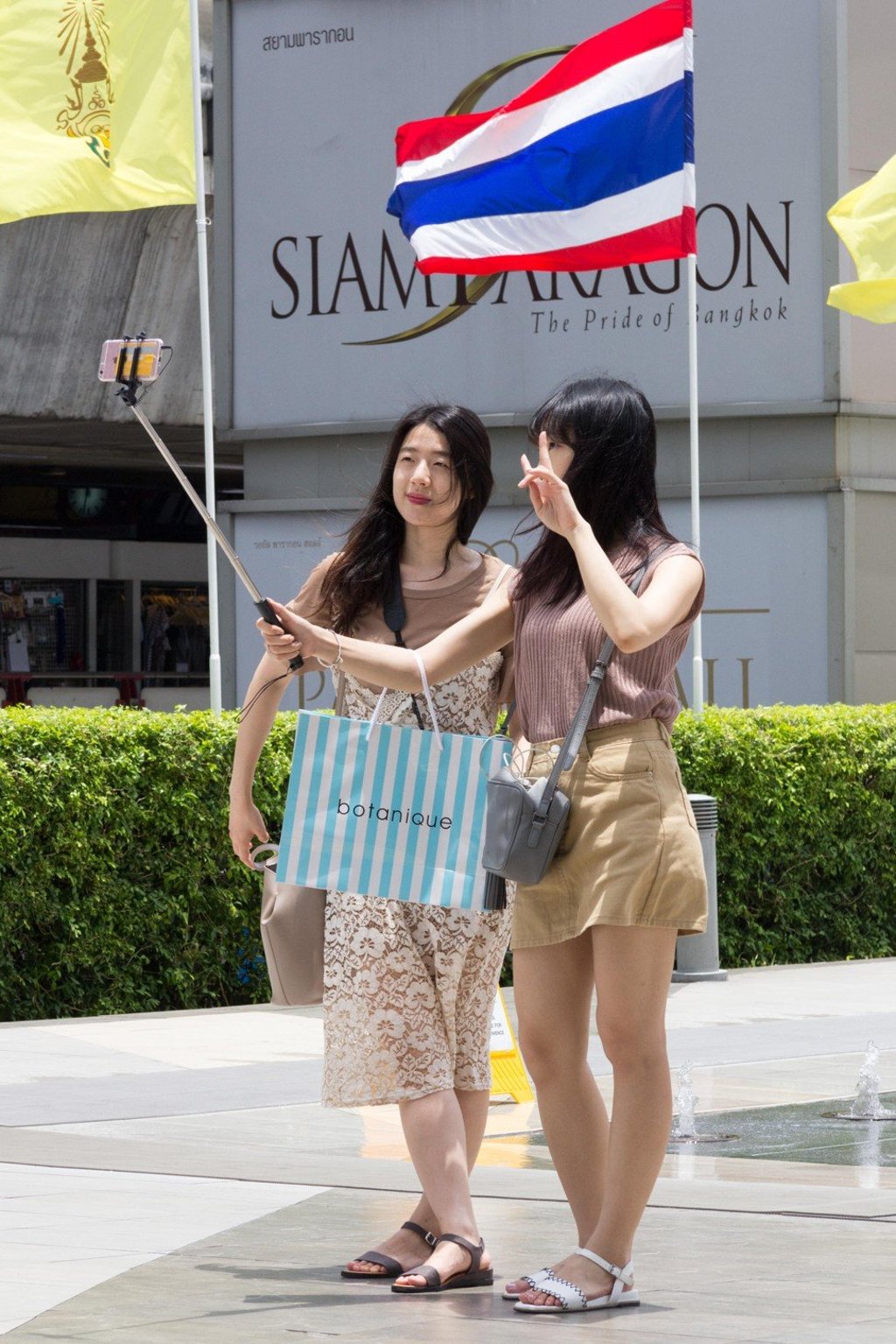 Chinese tourists take a selfie with the Thai flag outside Siam Paragon, Bangkok, Thailand. Photo: Alamy