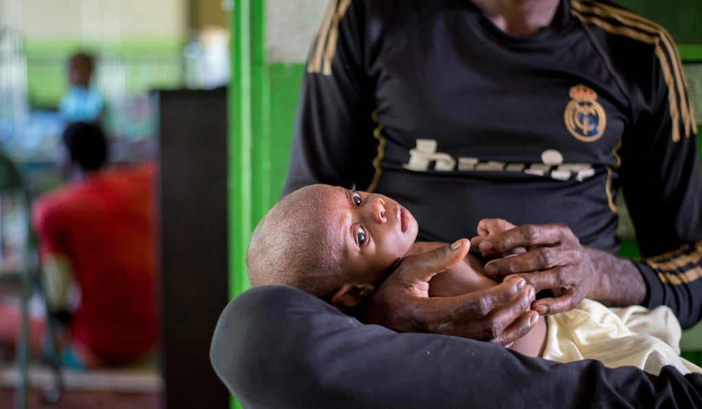 A Papuan man holds his child at a local hospital. Photo: AFP A Papuan man holds his child at a local hospital. Photo: AFP