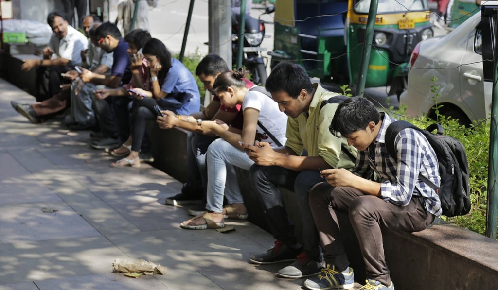Indians use their mobile phones in New Delhi, India. Photo: AP