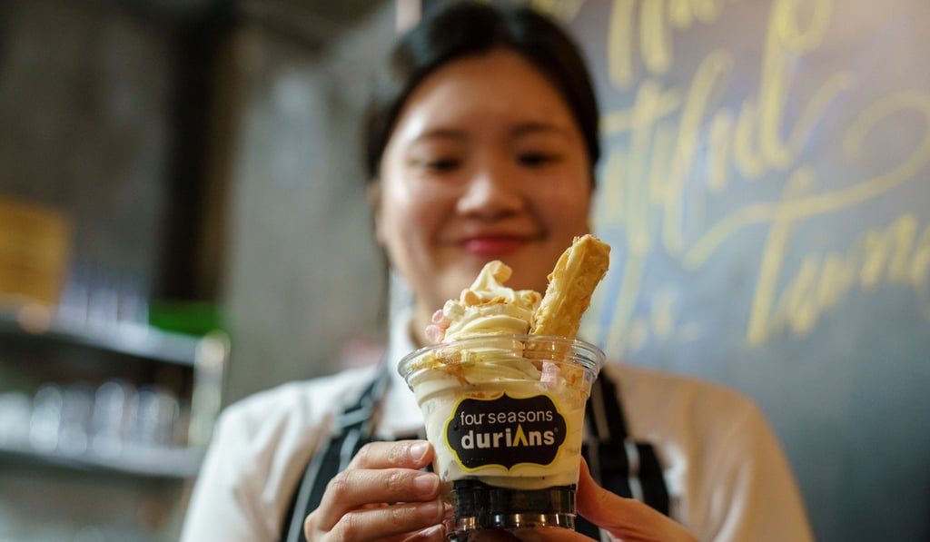 A staff member holds a cup of durian-flavoured ice cream. Photo: AFP