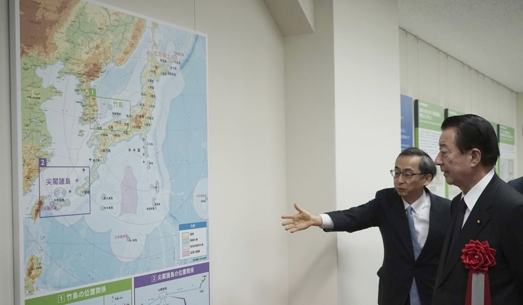 Tetsuma Esaki (right), minister in charge of territorial issues, is shown around the National Museum of Territory and Sovereignty in Tokyo that opened on January 25. The museum displays replicas of historic documents that Japan says show its ownership of two sets of uninhabited islands, one also claimed by China, the other by South Korea. Photo: AP
