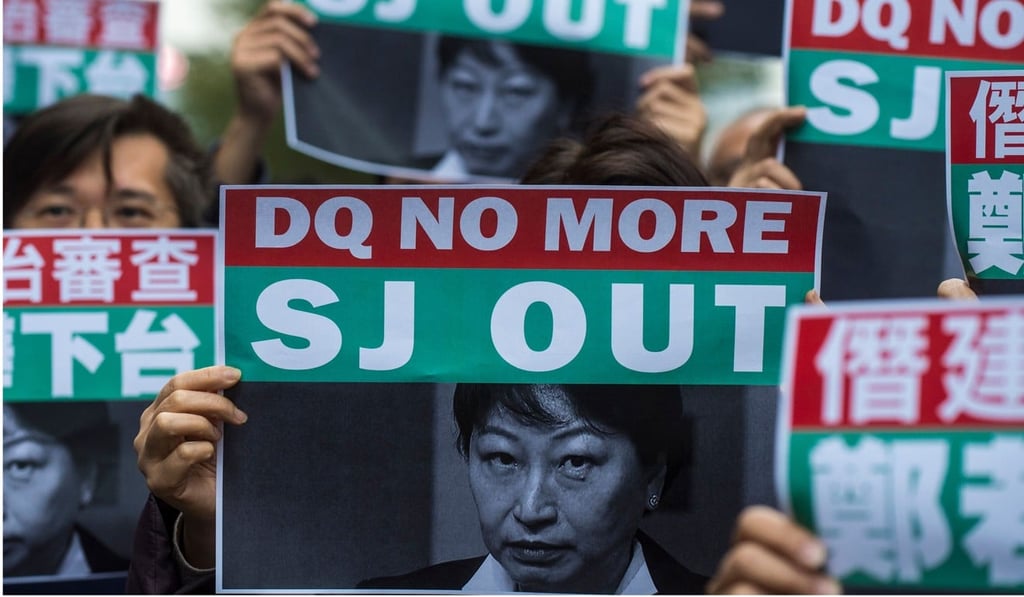 Protesters hold up posters of Secretary for Justice Teresa Cheng during a protest at the government headquarters in Hong Kong on January 28. The government trod carefully in handling the contentious nominations, knowing it would be caught between its obligation to safeguard political rights, and its duty to hold elections that conform to national and legal requirements about sincerity in upholding the Basic Law. Photo: AFP