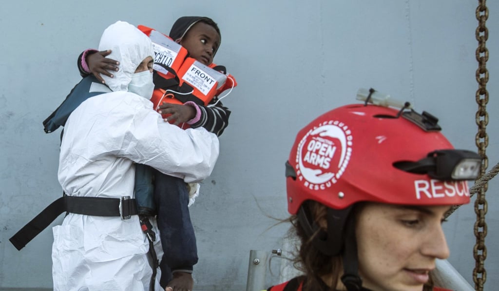 Aid workers from the Spanish NGO Proactiva Open Arms transfer a group of refugees and migrants from an overcrowded wooden boat to a Spanish warship, 45 miles north of Al-Khums, Libya on January 27, 2018. Photo: AP Aid workers from the Spanish NGO Proactiva Open Arms transfer a group of refugees and migrants from an overcrowded wooden boat to a Spanish warship, 45 miles north of Al-Khums, Libya on January 27, 2018. Photo: AP