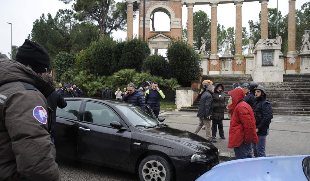 The black car Alfa Romeo of a young man suspected of wounding several foreign nationals in a drive-by shooting, is blocked by police and Carabibieri enforcement at Macerata, on February 3, 2018. Photo: AFP