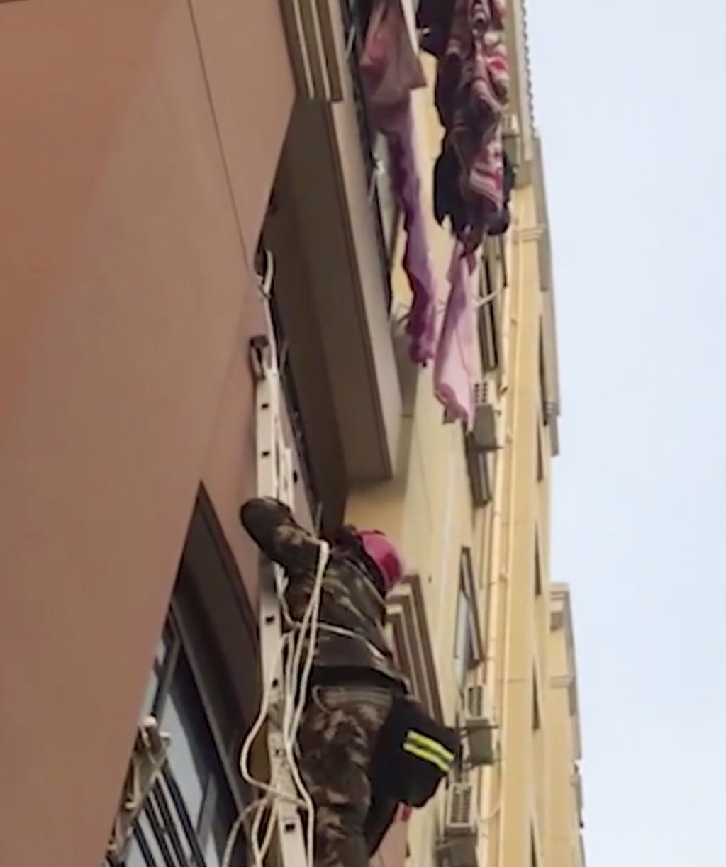 A firefighter climbs up to rescue the stranded child. Photo: News.163.com