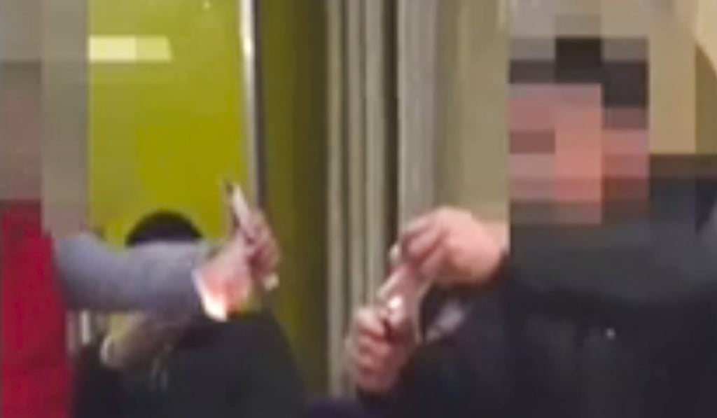 One of the men sets fire to a note with a cigarette lighter. Photo: Sina.com.cn