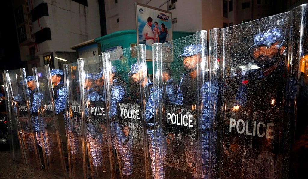 Maldivian police stand guard as opposition supporters protest against the government's delay in releasing their jailed leaders. Photo: Reuters