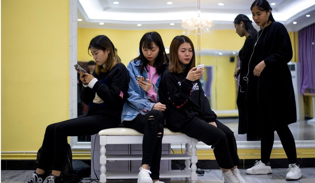 Students gaze at their smartphones at Yiwu Industrial and Commercial College in Zhejiang province in March 2017. China plans to assign all citizens a social-reliability rating to weed out potential troublemakers.Photo: AFP