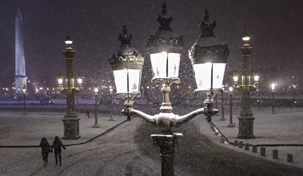 A couple walks across Place de la Concorde in Paris on Tuesday. Photo: EPA