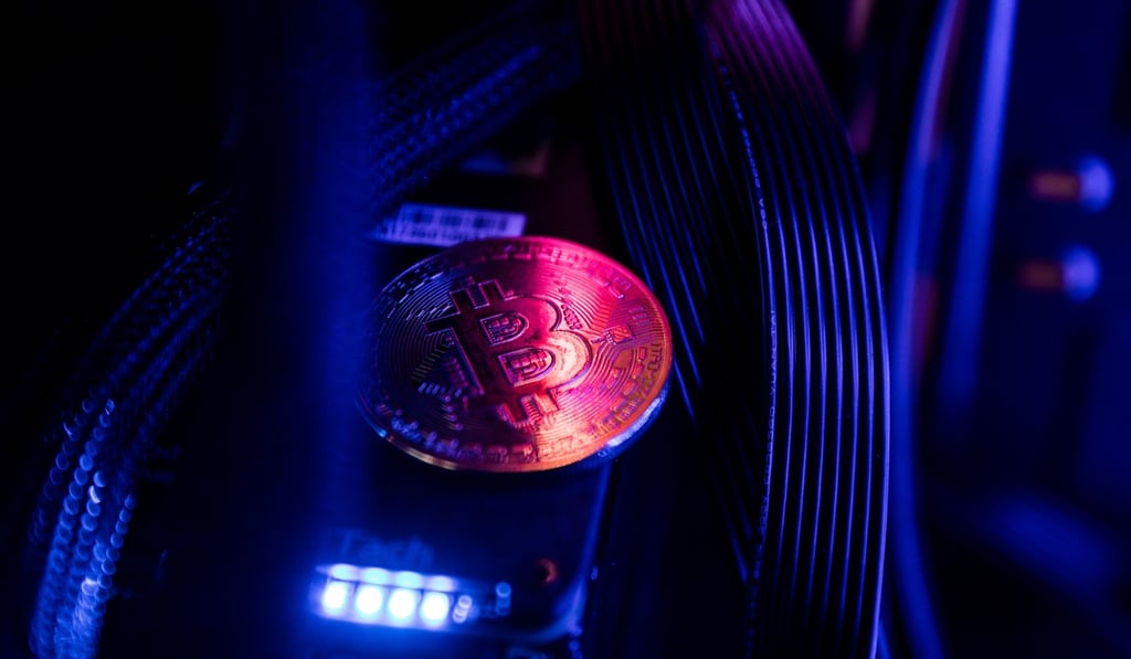 A bitcoin token sits among cables and LED lighting inside a 'mining rig'. Photo: Bloomberg