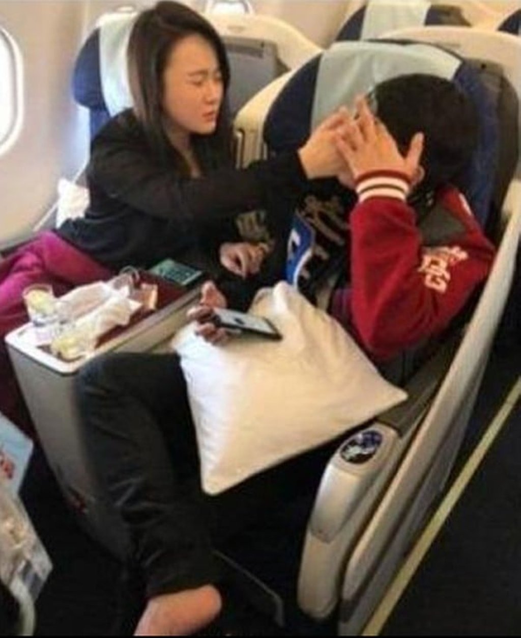 Zou is tended to by wife Ran Yingying on the flight to Shanghai. Photo: sina.com.cn