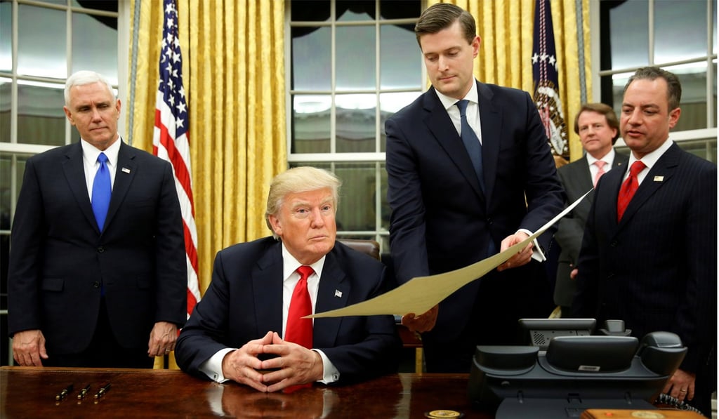 White House Staff Secretary Rob Porter gives US President Donald Trump the document to confirm Secretary of defence James Mattis on January 20, 2017. This was Trump's first signing in the Oval Office. Photo: Reuters