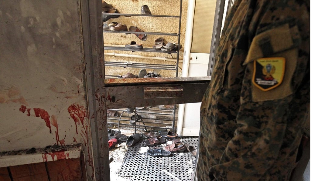 A Libyan wearing military fatigue inspects the interior of the mosque in Benghazi on Friday after it was hit by two bombs – one in a shoe storage area and one in a coffin. Photo: AFP A Libyan wearing military fatigue inspects the interior of the mosque in Benghazi on Friday after it was hit by two bombs – one in a shoe storage area and one in a coffin. Photo: AFP
