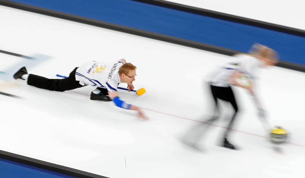Tomi Rantamaeki of Finland watches as teammate Oona Kauste sweeps. Photo: Reuters