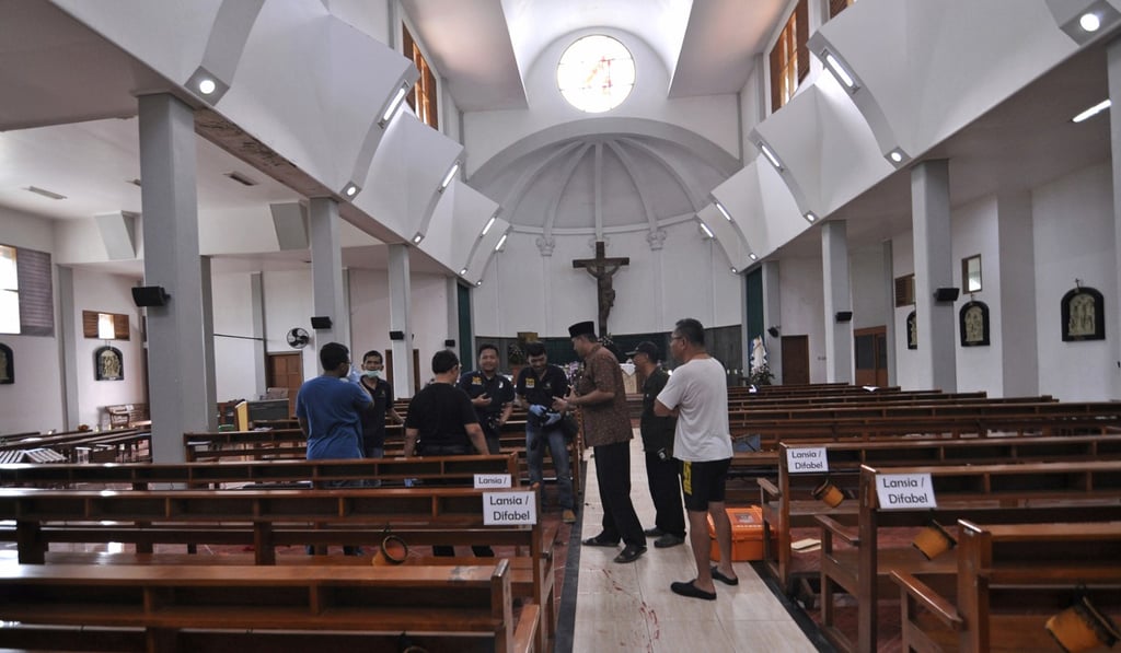 Police officers inside St Lidwina Church following the attack. Photo: AP