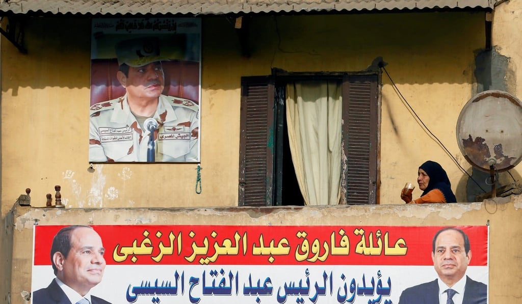 A woman sips on a cup of tea as she sits behind a poster of Egypt's President Abdel Fattah al-Sisi, who will run for a second term in an upcoming election, in Cairo, Egypt, on February 11, 2018. Photo: Reuters