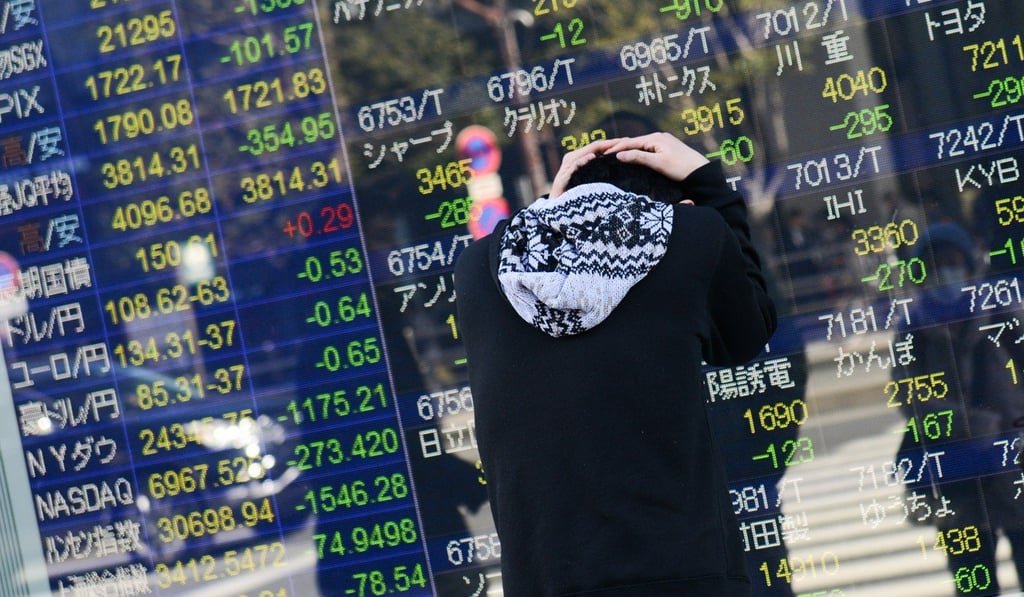 A man reacts after looking at an electronic stock board outside a securities firm in Tokyo, Japan, on February 6. Japan's blue-chip Nikkei 225 Stock Average entered a correction as the nation's shares posted the biggest decline since November 2016. Photo: Bloomberg
