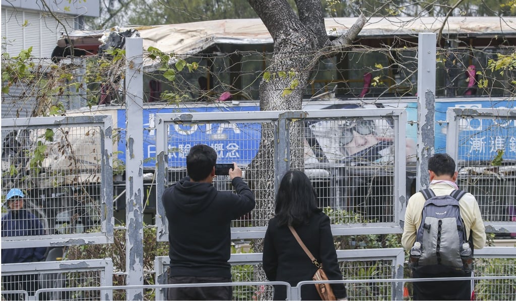 Passers-by at a police vehicle examination centre in Tai Lam Chung, Tuen Mun, take pictures of the bus involved in Saturday’s deadly crash. Photo: David Wong
