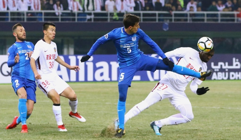 Kitchee’s Helio battles for the ball with Tianjin’s Anthony Modeste.