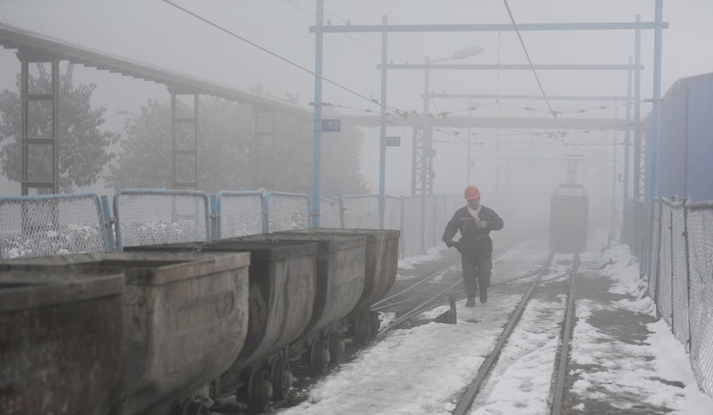 A coal worker walks next to wagons amid smog and snow in Huaibei, Anhui province, last month. Photo: Reuters