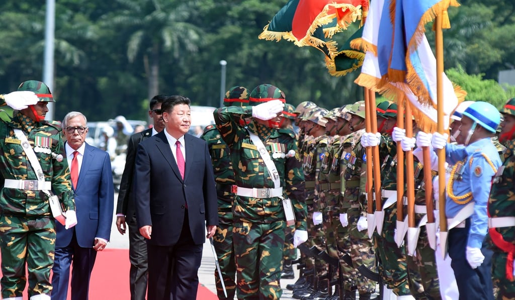 Chinese President Xi Jinping (centre) reviews an honour guard as he walks with Bangladesh's President Abdul Hamid after arriving in Dhaka in October 2016. There are complaints that Bangladesh is showing favouritism to India. Photo: AFP