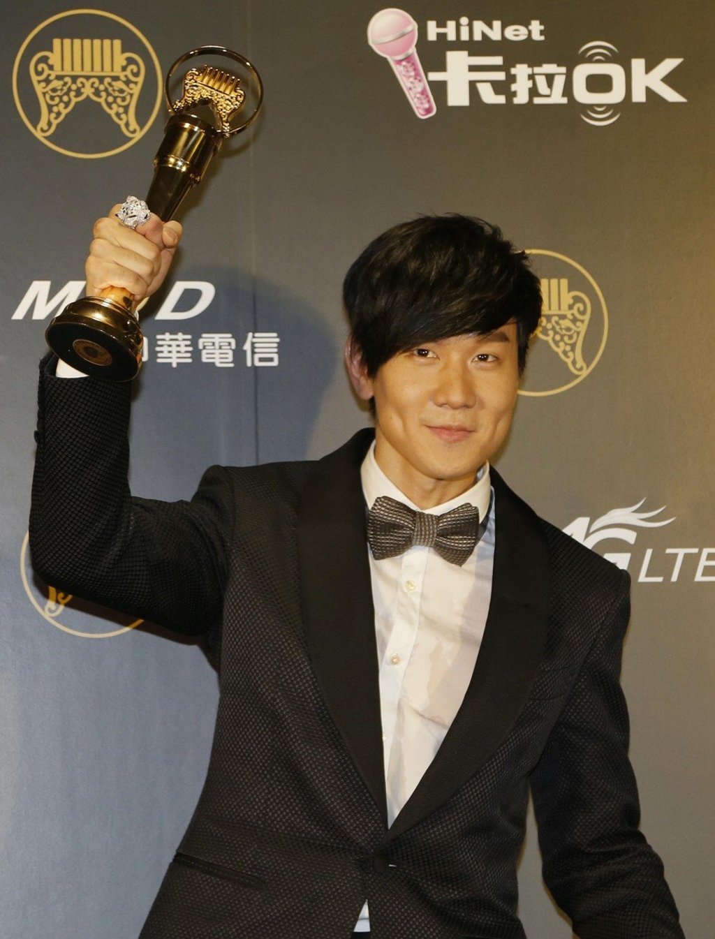 JJ Lin holds up his Golden Melody Award for Best Male Mandarin Singer in 2014. Photo: AP