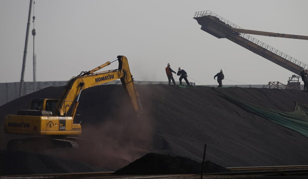 Workers are seen on a pile of iron ore at a steel factory in Tangshan, Hebei province, China, in 2015. File photo: Reuters