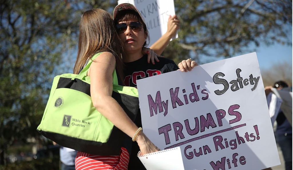 Debby Stout (right) whose daughter was in the Marjory Stoneman Douglas High School when 17 people were killed is given a hug as she joins others in protest against guns on February 17, 2018 in Parkland, Florida. Photo: Getty Images/AFP Debby Stout (right) whose daughter was in the Marjory Stoneman Douglas High School when 17 people were killed is given a hug as she joins others in protest against guns on February 17, 2018 in Parkland, Florida. Photo: Getty Images/AFP