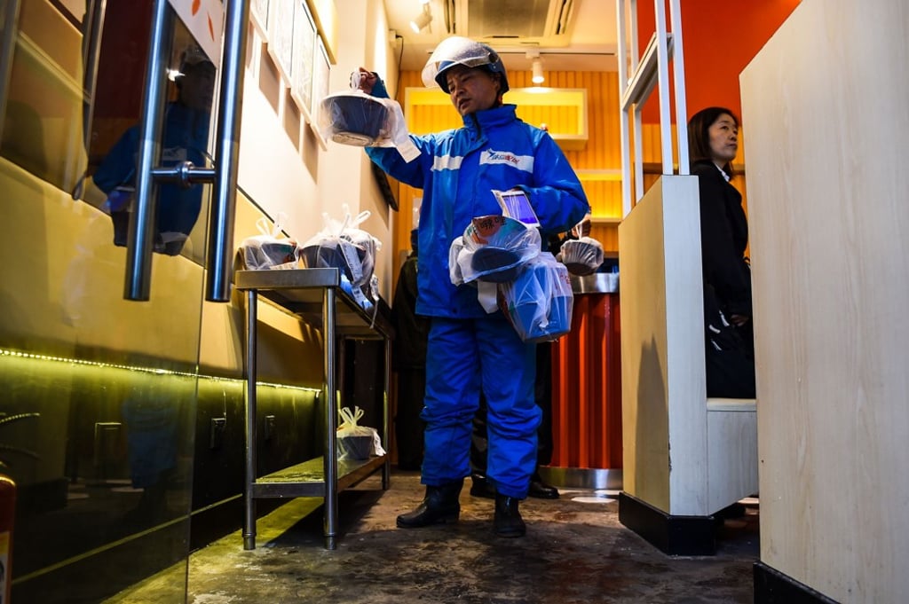 A deliveryman receives a food order at a restaurant in Shanghai. Photo: AFP A deliveryman receives a food order at a restaurant in Shanghai. Photo: AFP