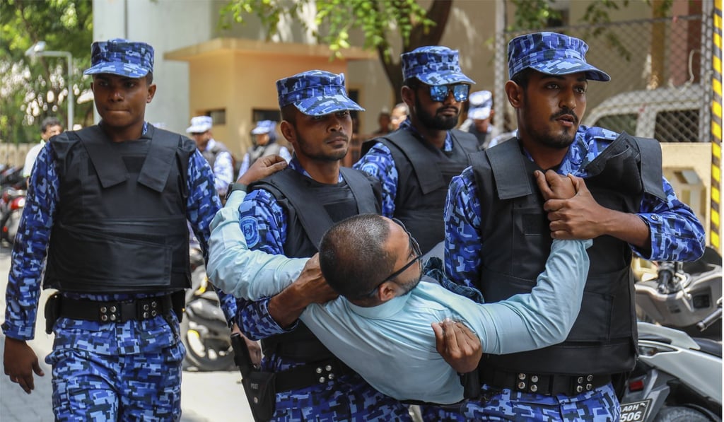 Maldivian police remove an opposition member who tried to enter the closed Parliament on February 15. Photo: AP